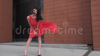 穿红色裙子的女孩微笑。 穿着<strong>风衣</strong>的美腿女孩。 风吹皱衣服。 慢动作